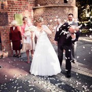 Fotografia ślubna (Karoliny i Rafała) przed kościołem, po ceremonii zaślubin - obsypywanie ryżem na szczęście.